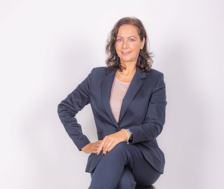 Karin Bacher sitzt auf einem Barhocker